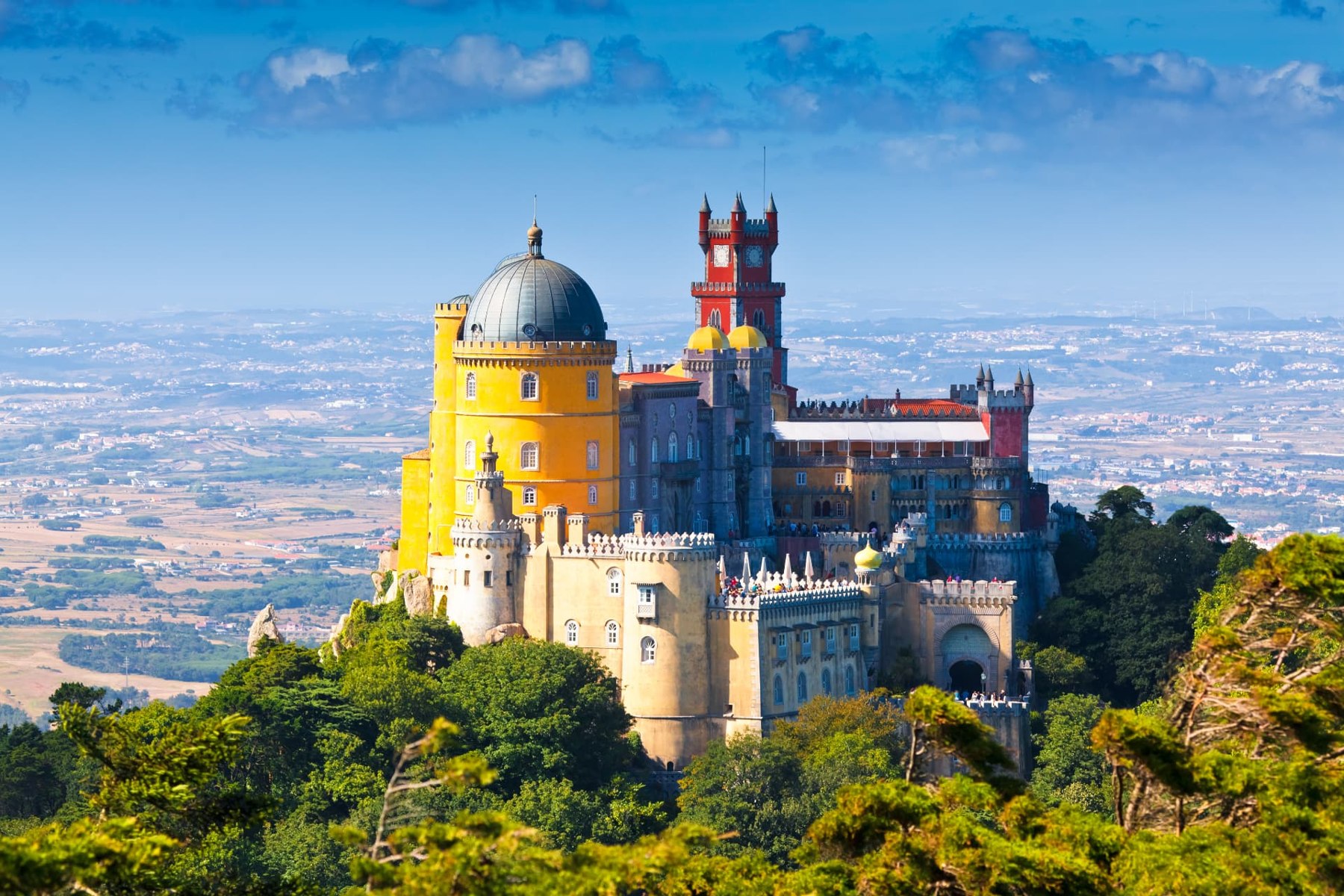 The colourful towers of Pena Palace above Sintra's wooded hills